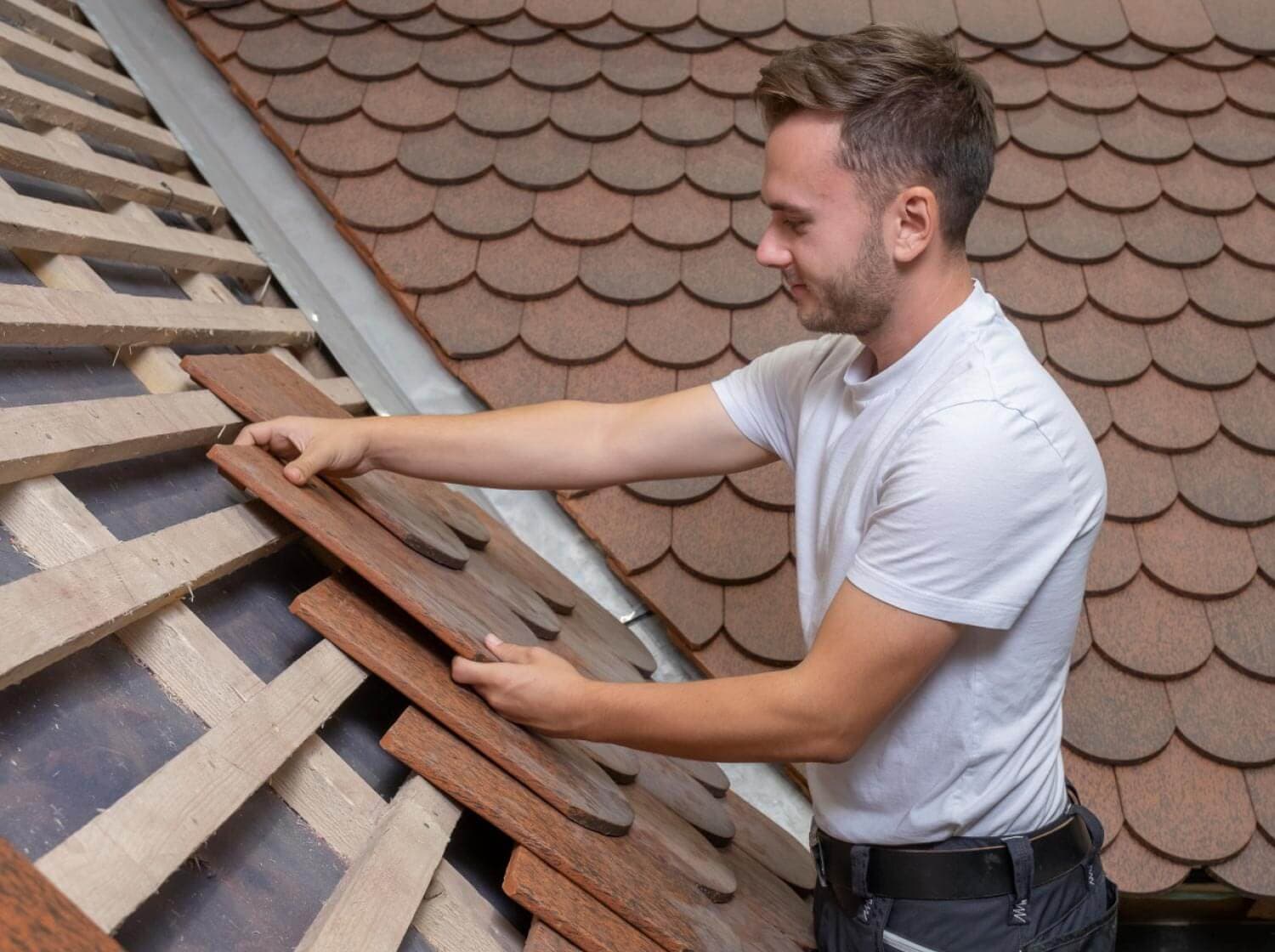 Ein Lehrling beim Anbringen einer Dachschindel